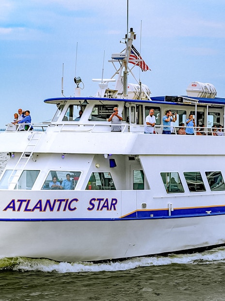 Tourists on the Atlantic Star cruise near New York City with the Verrazzano-Narrows Bridge in view.