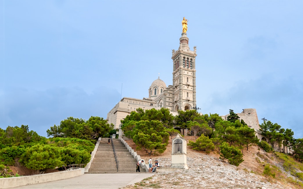 Basilique Notre-Dame de la Garde with steps and greenery in Marseille.