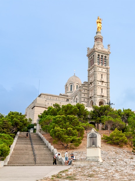 Basilique Notre-Dame de la Garde with steps and greenery in Marseille.