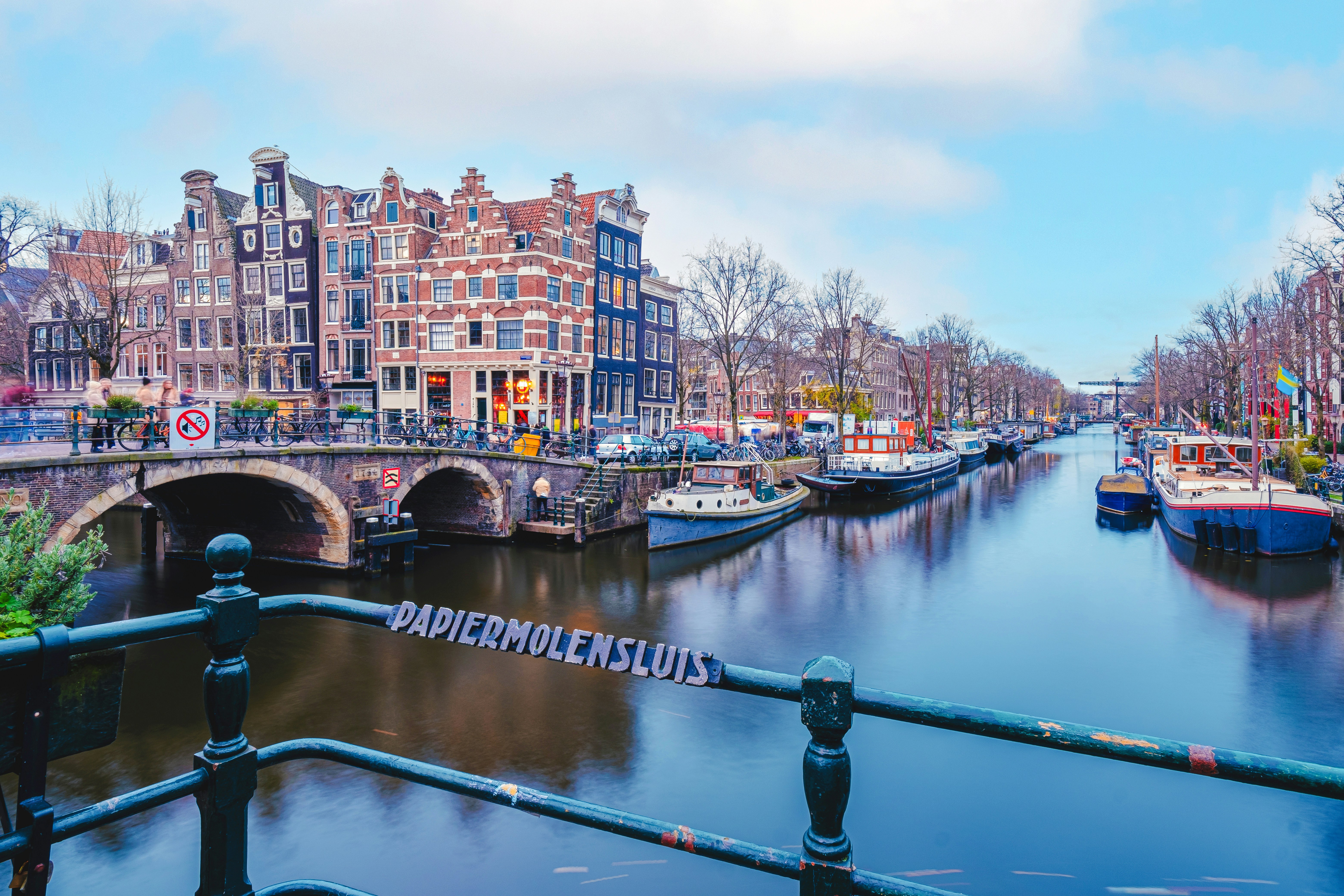 Canal view from Melkmeisjesbrug in Amsterdam with historic buildings and boats.