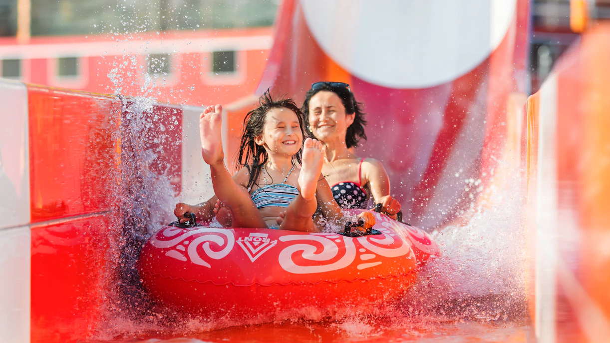 Mother and daughter enjoying a water slide at Aquaventure, Dubai.