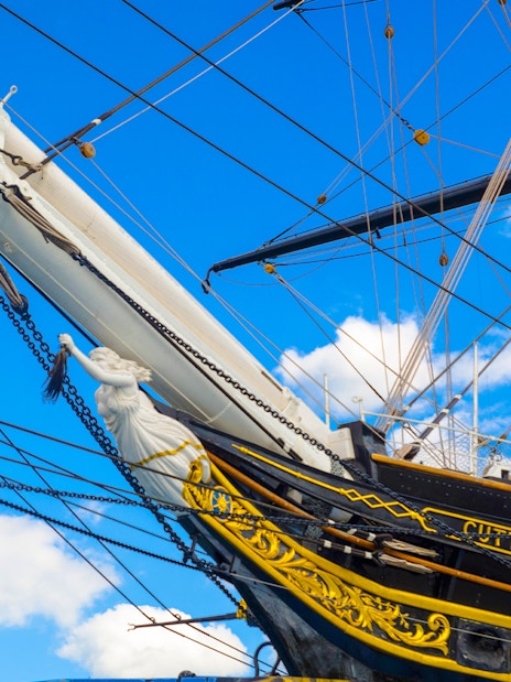 Cutty Sark ship's bow and figurehead against a blue sky in Greenwich.