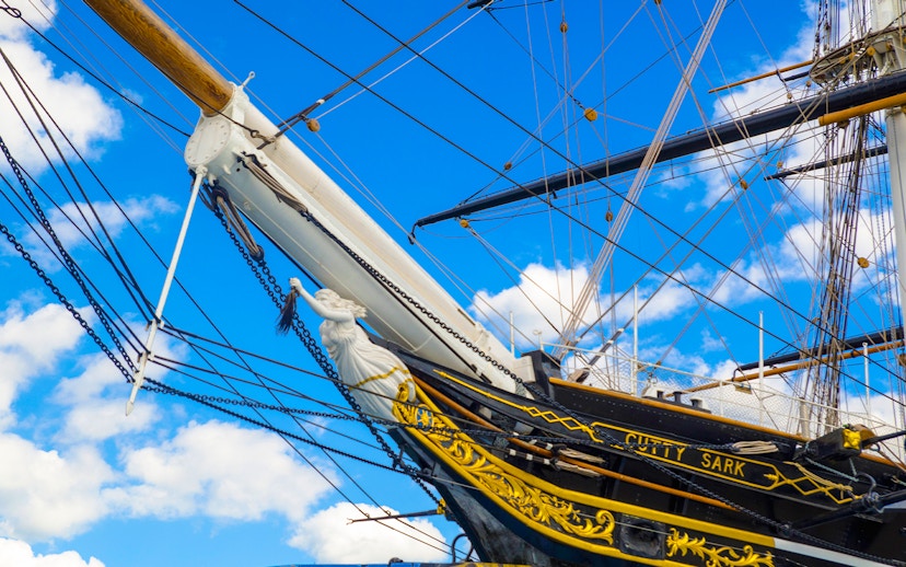 Cutty Sark ship's bow and figurehead against a blue sky in Greenwich.