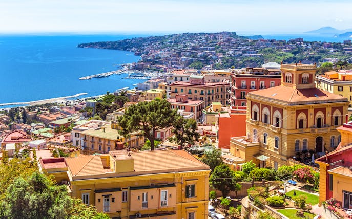 Naples cityscape with colorful buildings and coastline, view from above.