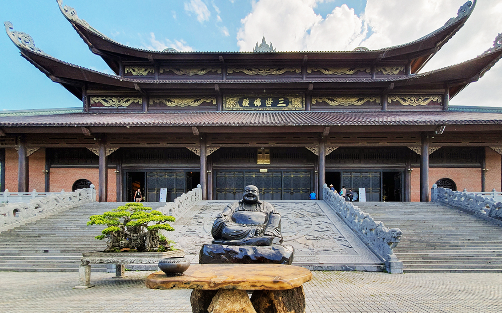 Buddha statue and bonsai tree at Bái Đính Pagoda entrance, Ninh Bình Province, Vietnam.