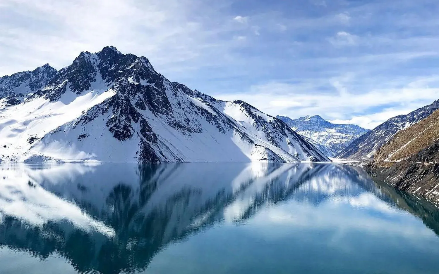 Snow-capped Andes mountains reflecting in Embalse El Yeso, Santiago, Chile.