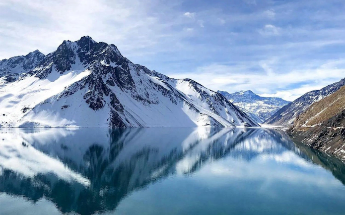 Snow-capped Andes mountains reflecting in Embalse El Yeso, Santiago, Chile.