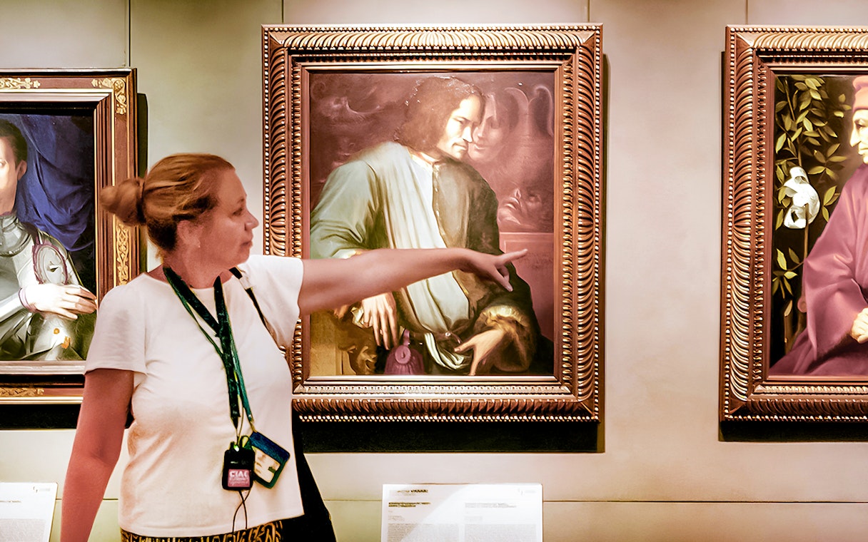 Tour guide pointing at painting in Uffizi Gallery, Florence Wonders tour.