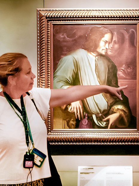 Tour guide pointing at painting in Uffizi Gallery, Florence Wonders tour.