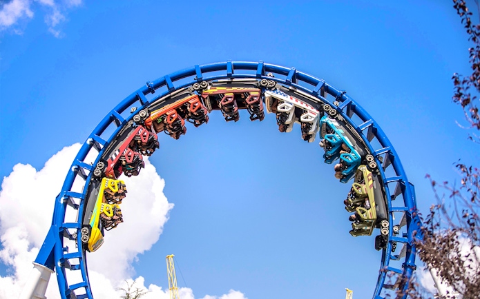 Roller coaster loop at Six Flags Carowinds, The Flying Cobras ride against blue sky.