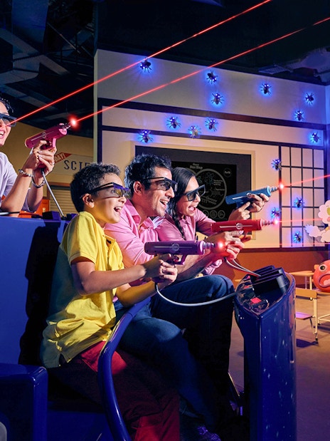 Visitors enjoying a 3D dinosaur-themed ride at IMG Worlds of Adventure in Dubai.