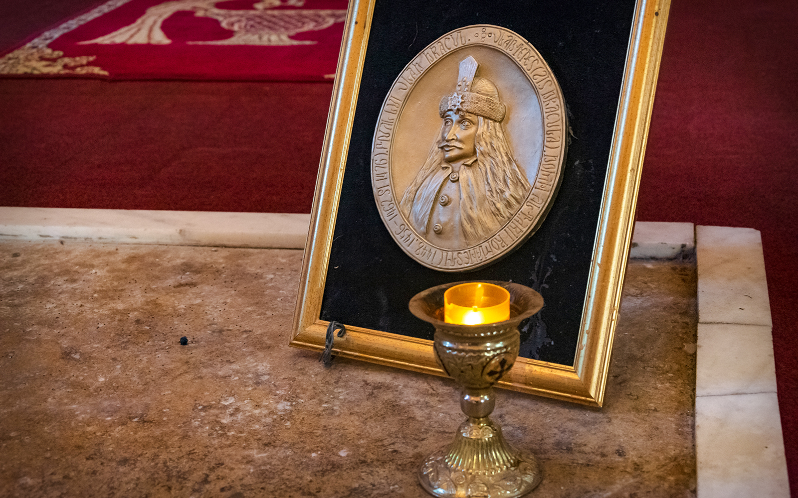 Dracula's Tomb plaque and candle inside Snagov Monastery, Romania.