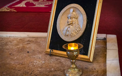 Dracula's Tomb plaque and candle inside Snagov Monastery, Romania.