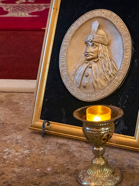Dracula's Tomb plaque and candle inside Snagov Monastery, Romania.