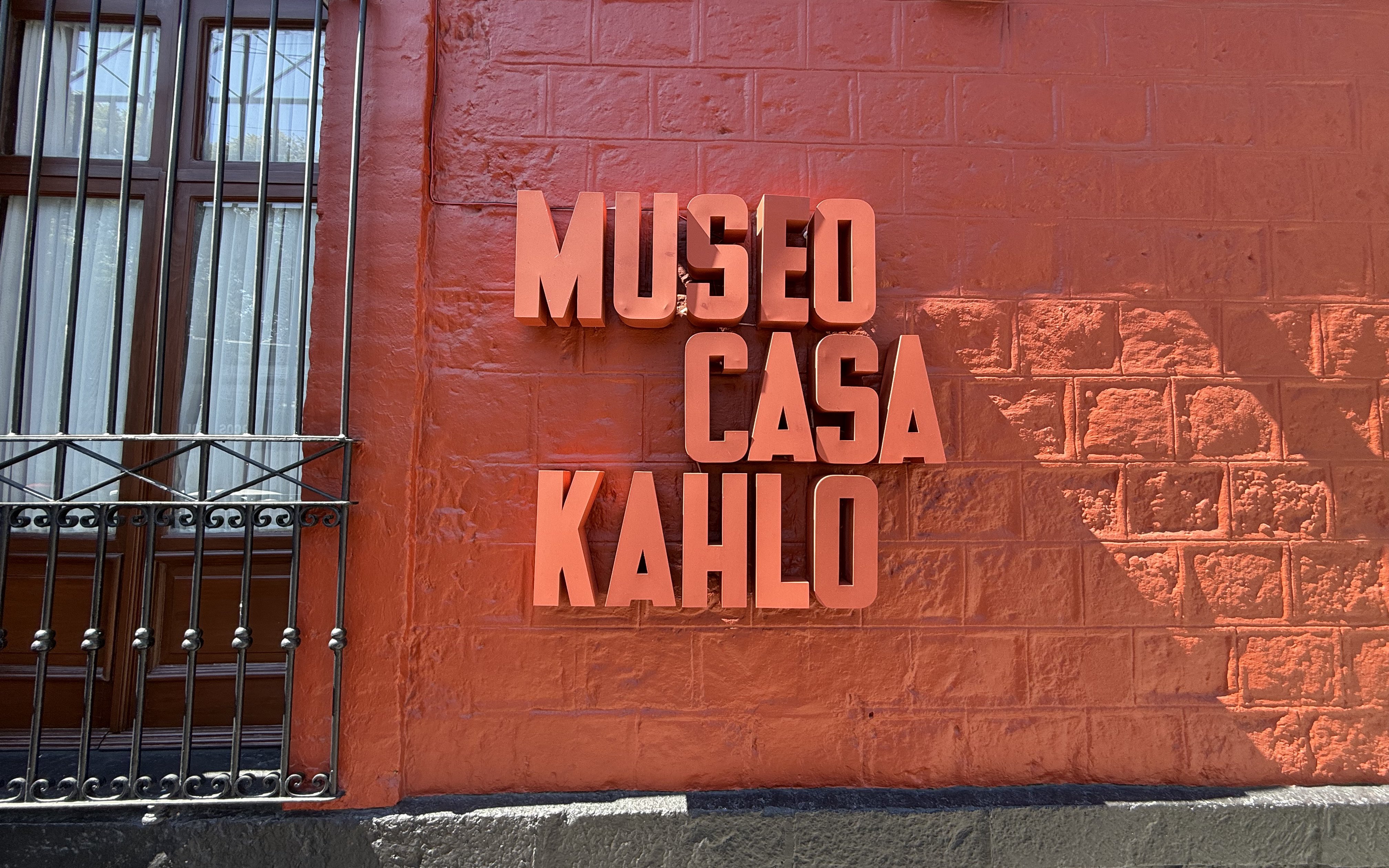 Frida Kahlo Museum sign on red wall at La Casa Roja.