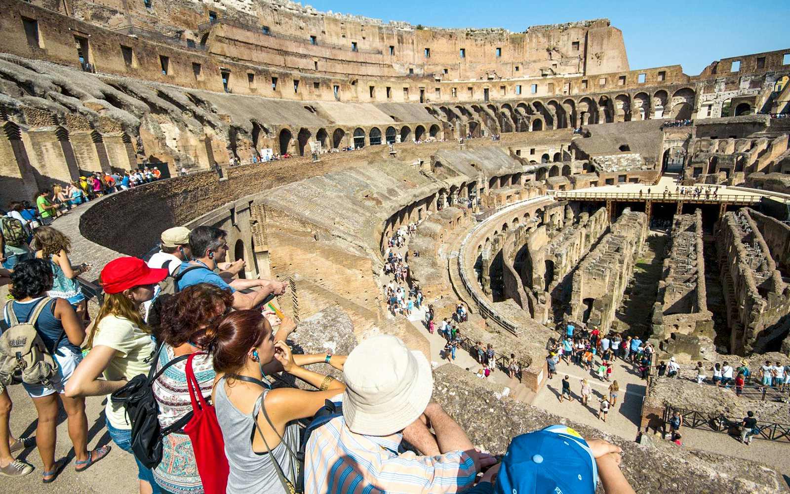 Tourists with a guide overlooking the interior of the Colosseum in Rome, Italy.