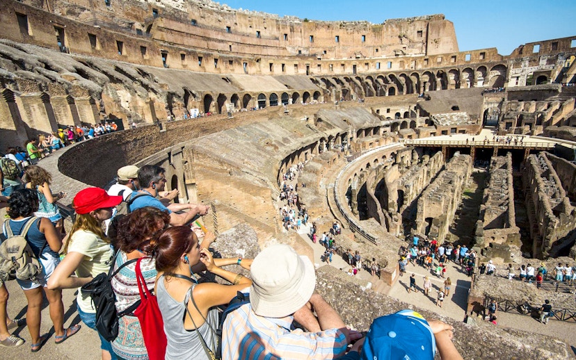 Tourists with a guide overlooking the interior of the Colosseum in Rome, Italy.