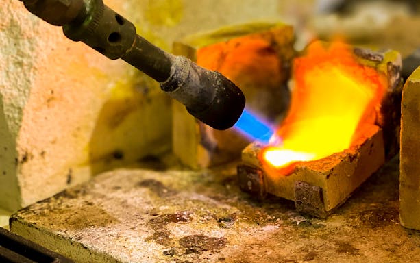 Jewelry-making with torch and molten metal in Oristano workshop.