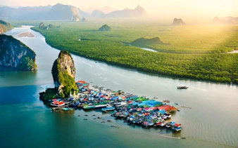 Floating village near limestone cliffs in Phang Nga Bay, Phuket, Thailand.