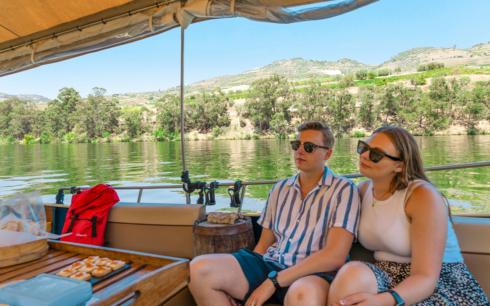 Tourists on a boat enjoying a cruise in Douro Valley, Portugal, with scenic river views.