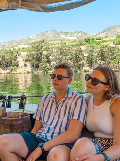 Tourists on a boat enjoying a cruise in Douro Valley, Portugal, with scenic river views.