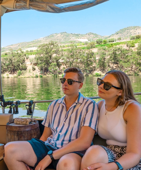 Tourists on a boat enjoying a cruise in Douro Valley, Portugal, with scenic river views.