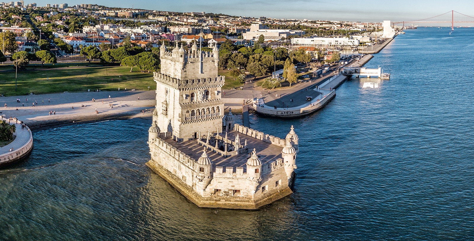 Belem Tower in Lisbon, Portugal, surrounded by water with cityscape in the background.