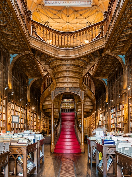 Lello Library interior with ornate wooden staircase and bookshelves, Porto, Portugal.