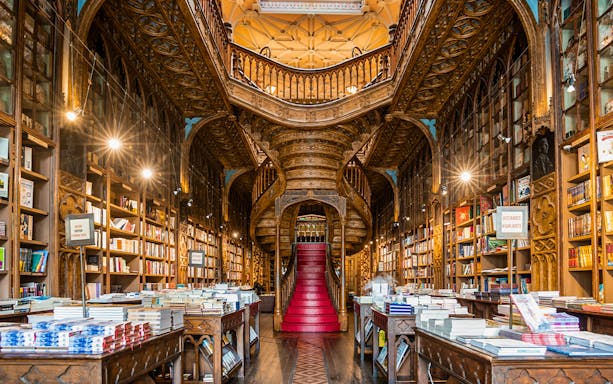Lello Library interior with ornate wooden staircase and bookshelves, Porto, Portugal.