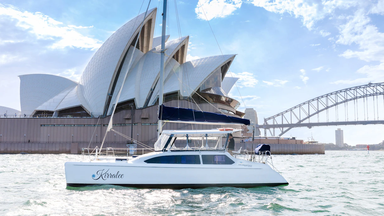 Luxury yacht cruising near Sydney Opera House and Harbour Bridge during Vivid Sydney.