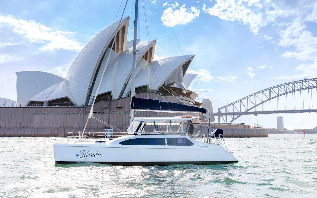 Luxury yacht cruising near Sydney Opera House and Harbour Bridge during Vivid Sydney.