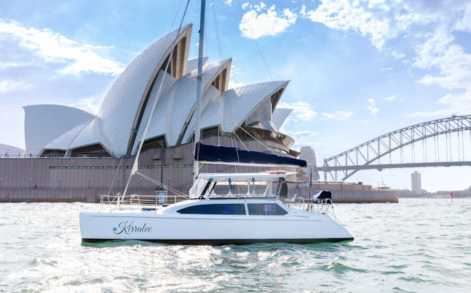 Luxury yacht cruising near Sydney Opera House and Harbour Bridge during Vivid Sydney.