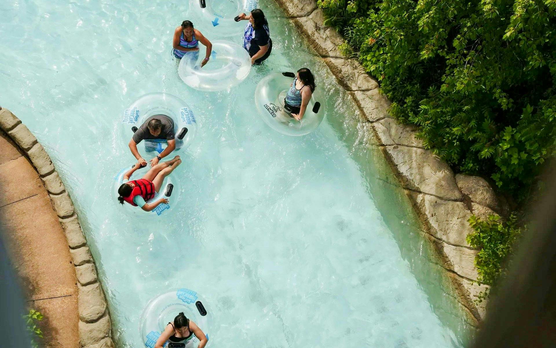 People floating on inner tubes in a lazy river at Hurricane Harbor Chicago.