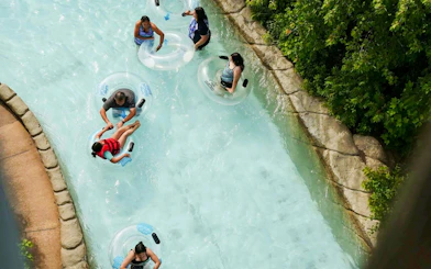 People floating on inner tubes in a lazy river at Hurricane Harbor Chicago.