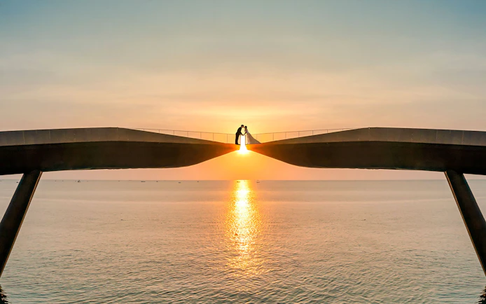 Couple on Kiss Bridge at sunset, Phu Quoc Island, Vietnam.