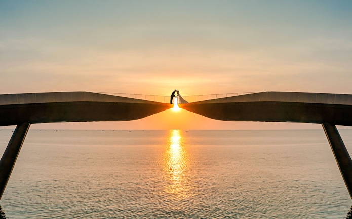 Couple on Kiss Bridge at sunset, Phu Quoc Island, Vietnam.