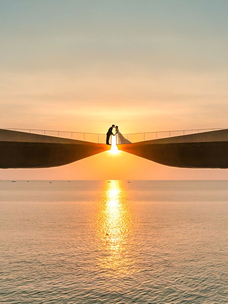 Couple on Kiss Bridge at sunset, Phu Quoc Island, Vietnam.