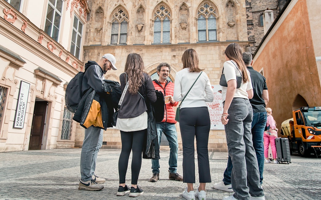 Tour group with guide in Prague Old Town near historic building.