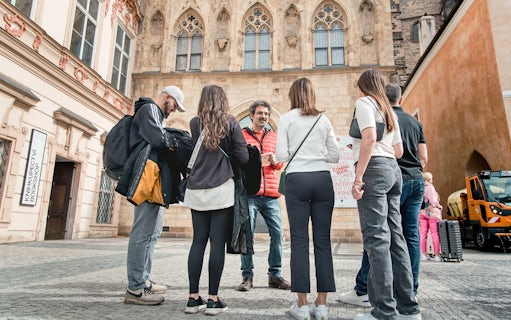 Tour group with guide in Prague Old Town near historic building.