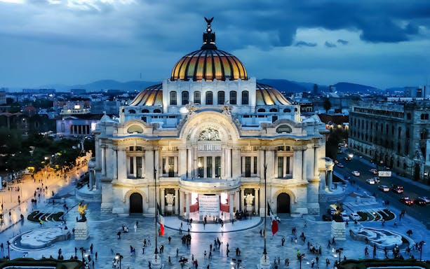 Palacio de Bellas Artes illuminated at dusk, Mexico City guided tour.