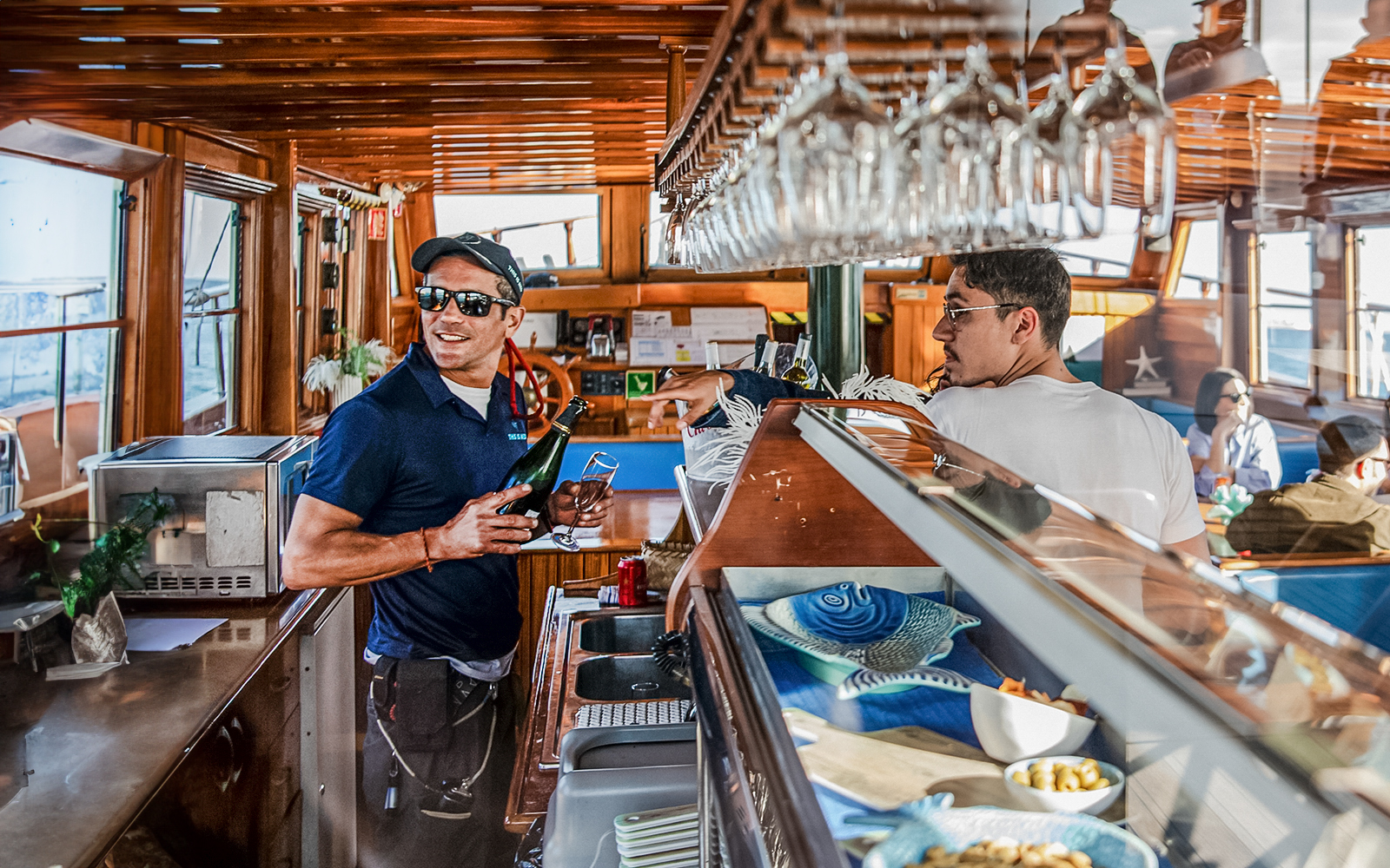 Bar on a catamaran in Barcelona with a crew member serving drinks.