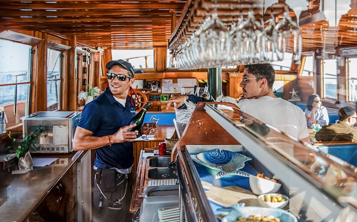 Bar on a catamaran in Barcelona with a crew member serving drinks.