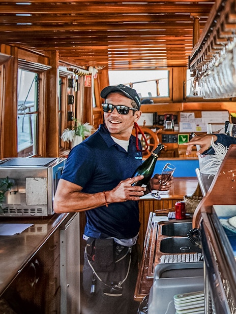 Bar on a catamaran in Barcelona with a crew member serving drinks.