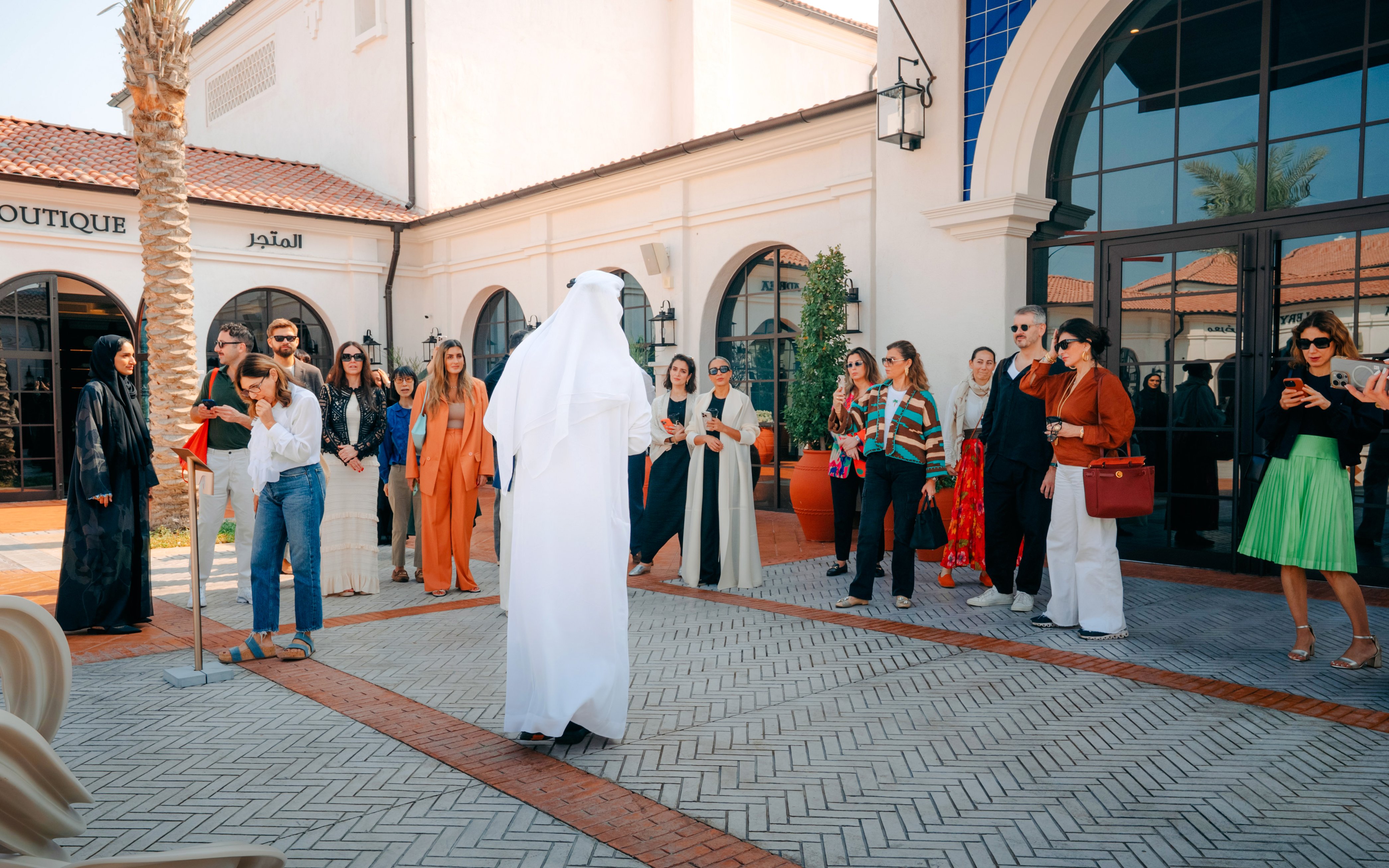 Tour group at Abu Dhabi Royal Equestrian Arts, guide in traditional attire leading.