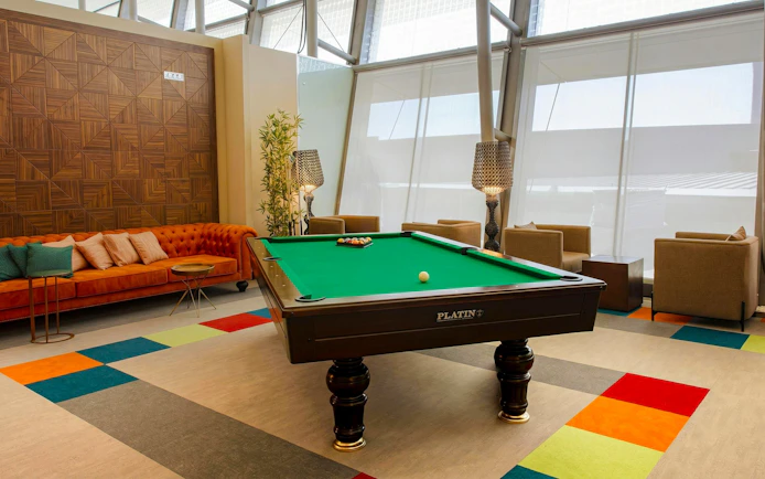 Pool table and seating area at Primeclass Lounge, Muscat International Airport departures.