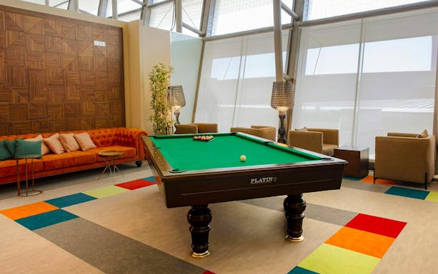 Pool table and seating area at Primeclass Lounge, Muscat International Airport departures.