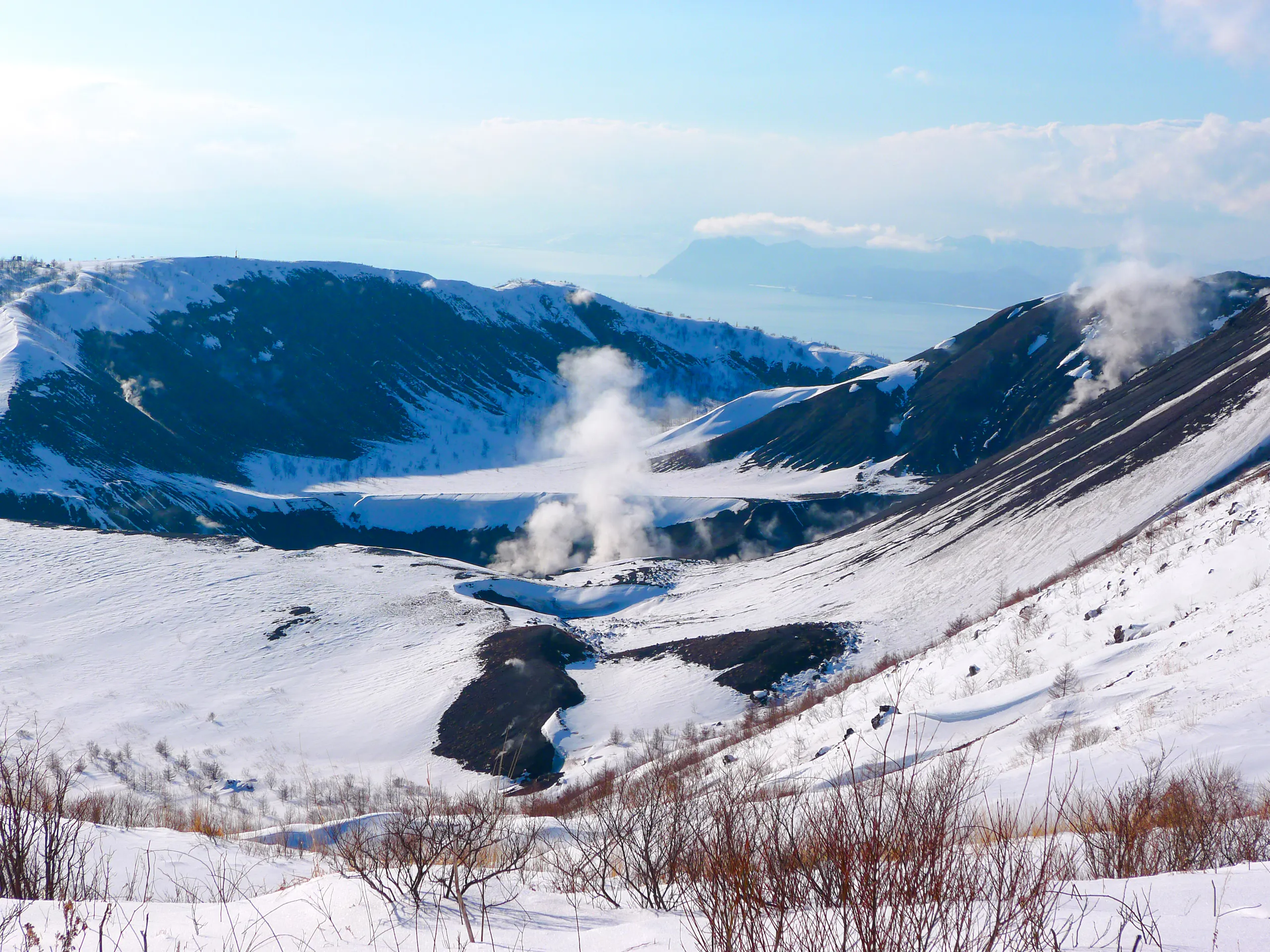 Snow-covered Noboribetsu Hell Valley with steam vents, Hokkaido winter landscape.