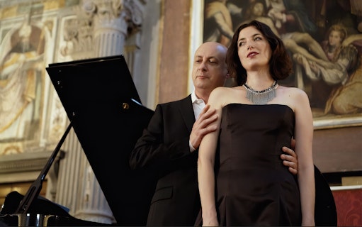 Opera singers performing at a concert in Florence with classical art in the background.