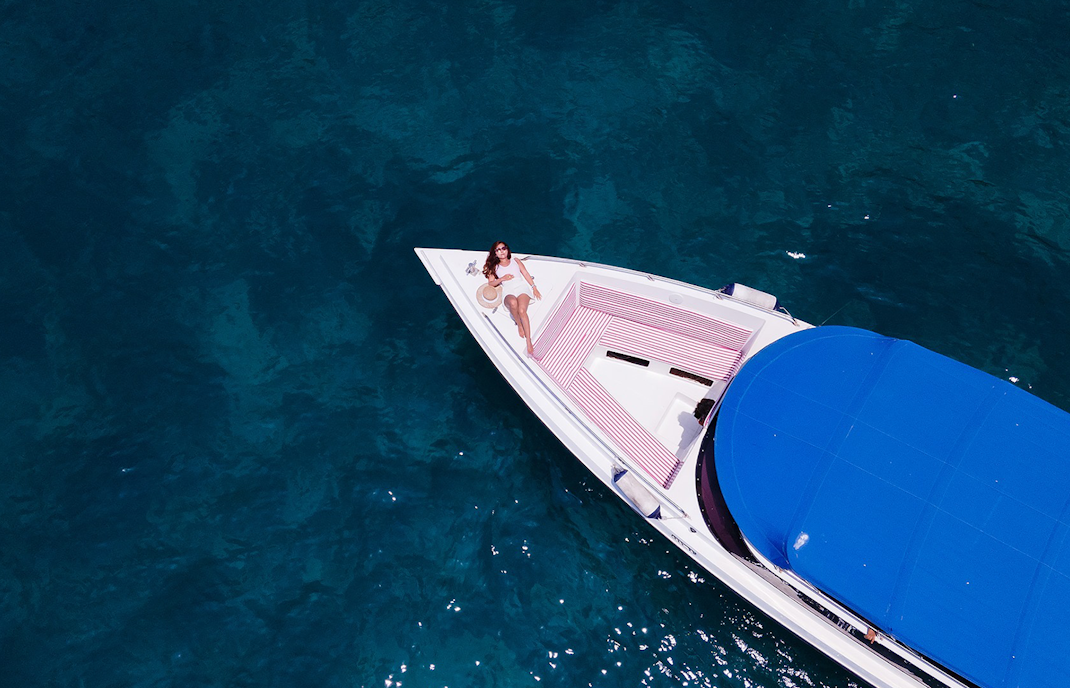 Woman relaxing on a speedboat in clear water near Phi Phi Islands.
