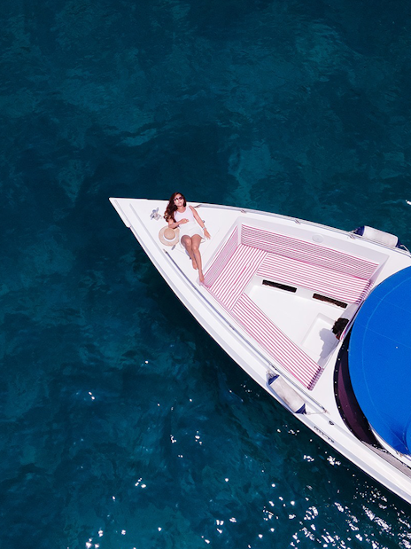 Woman relaxing on a speedboat in clear water near Phi Phi Islands.